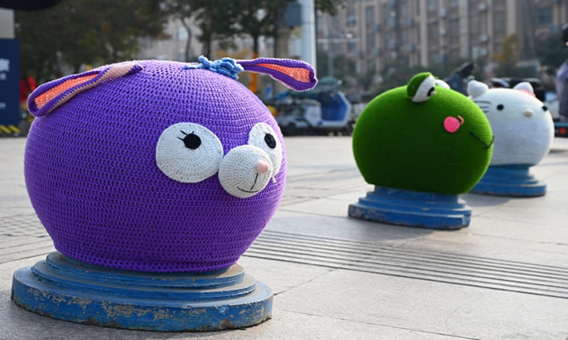 Trees and stone bollards in front of a shopping plaza in Xuzhou, East China's Jiangsu Province, are adorned with colorful knitted sweaters, on December 11, 2024. Photo: VCG