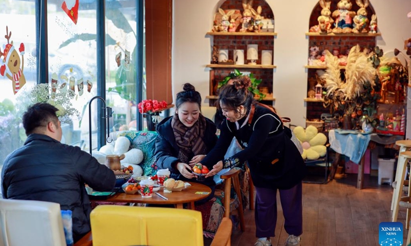 A homestay operator (1st R) serves food for tourists at her homestay in Tianfu Town of Beibei District, southwest China's Chongqing Municipality, Dec. 11, 2024. In recent years, the town of Tianfu, with unique natural scenery as well as abundant resources for cultural tourism in its countryside, has promoted the improvement of village environment and the upgrading of infrastructure. The town has transformed vacant rural houses into a group of high-quality homestays, which not only accommodate tourists with an immersive rural experience, but also bring lucrative job opportunities to local villagers. (Xinhua/Liu Chan)