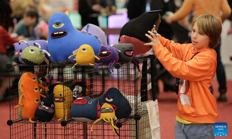 A child looks at stuffed toys during the annual Make It Show in Vancouver, British Columbia, Canada, Dec. 12, 2024. The annual event showcases a diverse array of handmade goods from over 250 artists, makers and craftsmen. (Photo by Liang Sen/Xinhua)