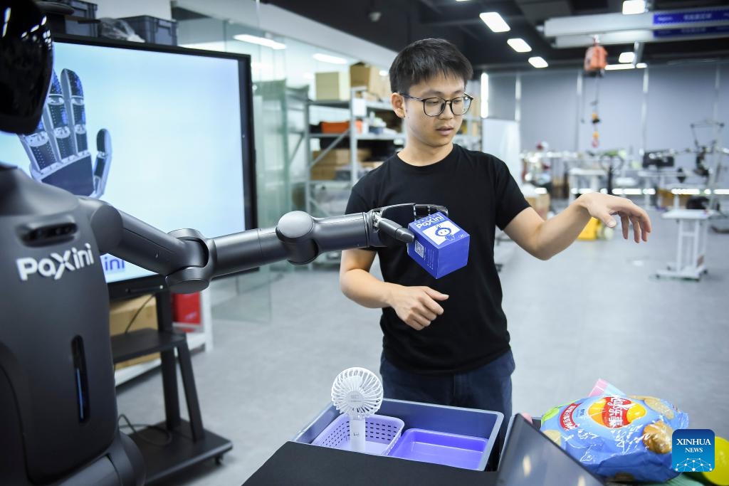 A staff member conducts tests on a Walker X humanoid robot at a sci-tech company in Shenzhen, south China's Guangdong Province, June 26, 2024. The Guangdong-Hong Kong-Macao Greater Bay Area, with its outstanding capabilities in research and development and solid foundation for manufacturing, serves as a fertile ground for the development of humanoid robot sector. (Photo: Xinhua)