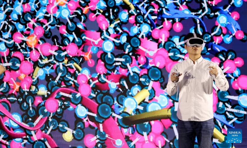 A man participates in a demonstration of smart education showcasing a scenario of a future computational biology class using AI, digital twin and virtual reality (VR) technologies, during an international conference on online education and massive open online courses (MOOC) in London, Britain, on Dec. 12, 2024. (Photo: Xinhua)