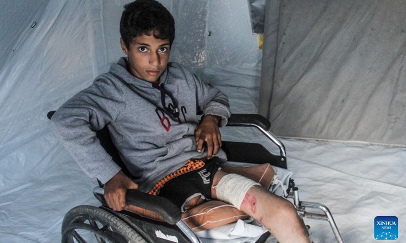 Akram Harb sits in a shelter in Gaza City, on Dec. 13, 2024. Harb, a 13-year-old Palestinian, was injured in an Israeli attack at his house in the Jabalia refugee camp in the northern Gaza Strip in October, 2024. (Photo: Xinhua)