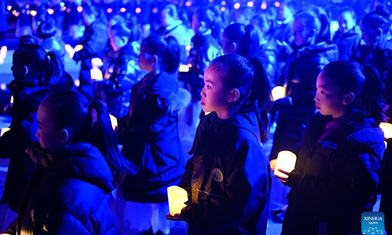 Children attend a candle light vigil at the Memorial Hall of the Victims in Nanjing Massacre by Japanese Invaders in Nanjing, capital of east China's Jiangsu Province, Dec. 13, 2024. A candle light vigil was held here on Friday to mark this year's national memorial day for the victims of the Nanjing Massacre.(Photo: Xinhua)