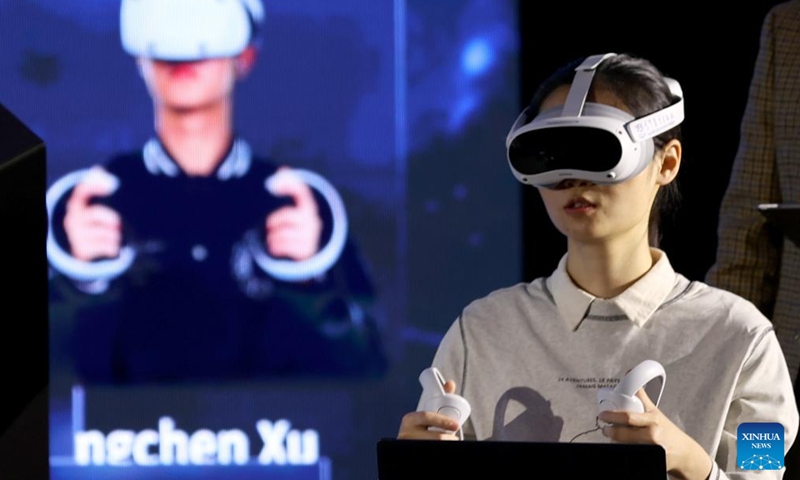 A woman participates in a demonstration of smart education showcasing a scenario of a future computational biology class using AI, digital twin and virtual reality (VR) technologies, during an international conference on online education and massive open online courses (MOOC) in London, Britain, on Dec. 12, 2024. (Photo: Xinhua)