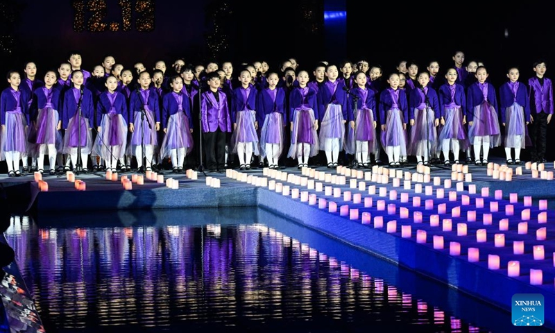 Children sing a song while attending a candle light vigil at the Memorial Hall of the Victims in Nanjing Massacre by Japanese Invaders in Nanjing, capital of east China's Jiangsu Province, Dec. 13, 2024. A candle light vigil was held here on Friday to mark this year's national memorial day for the victims of the Nanjing Massacre. (Photo: Xinhua)