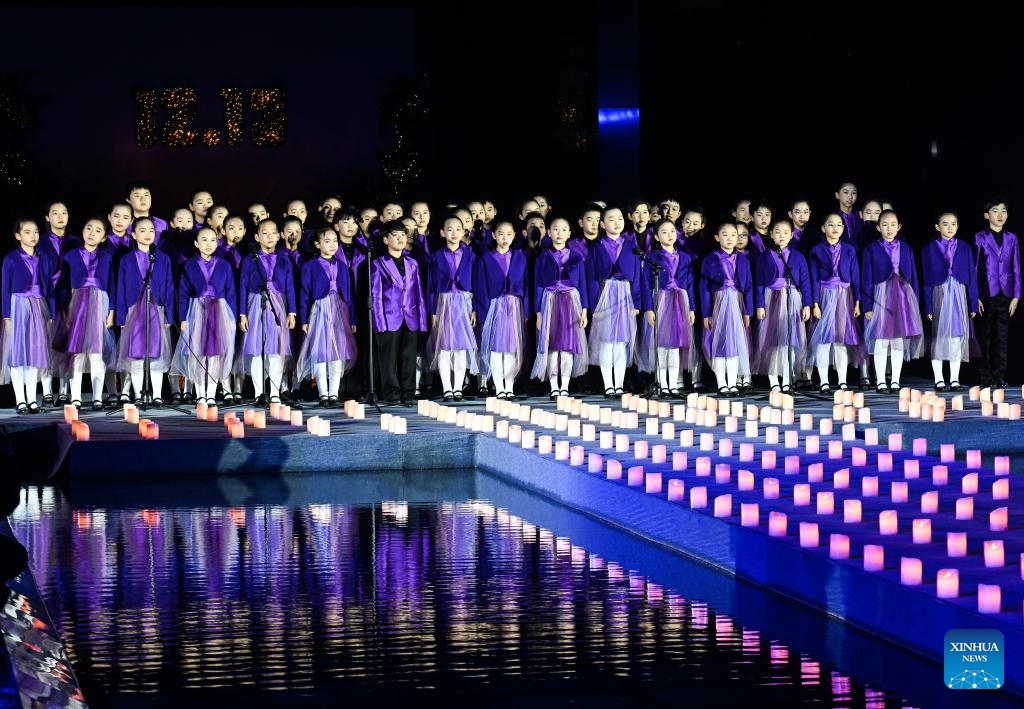 Children sing a song while attending a candle light vigil at the Memorial Hall of the Victims in Nanjing Massacre by Japanese Invaders in Nanjing, capital of east China's Jiangsu Province, Dec. 13, 2024. A candle light vigil was held here on Friday to mark this year's national memorial day for the victims of the Nanjing Massacre. (Photo: Xinhua)