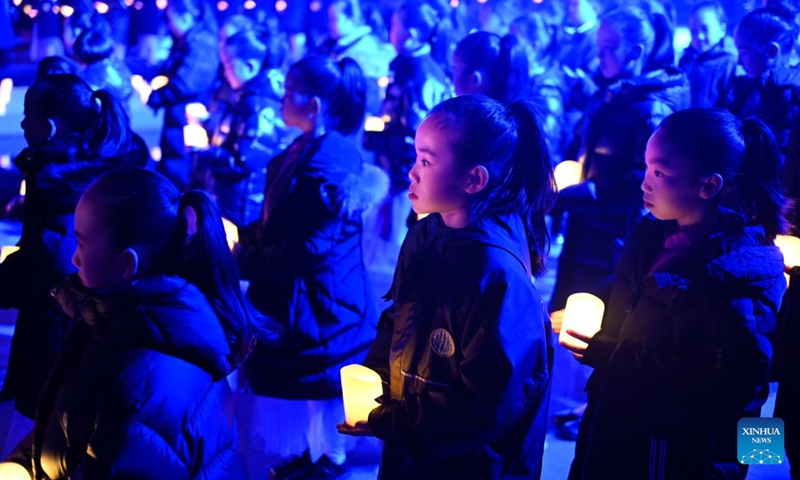 Children attend a candle light vigil at the Memorial Hall of the Victims in Nanjing Massacre by Japanese Invaders in Nanjing, capital of east China's Jiangsu Province, Dec. 13, 2024. A candle light vigil was held here on Friday to mark this year's national memorial day for the victims of the Nanjing Massacre. (Photo: Xinhua)