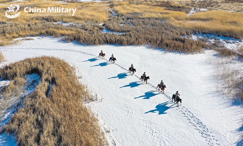 Soldiers attached to the Takixken border defense company under the Chinese PLA Xinjiang Military Command carefully steer their horses to pass through snow-covered wetland during a routine patrol mission on November 29, 2024. (eng.chinamil.com.cn/Photo by Xiao Guotao)