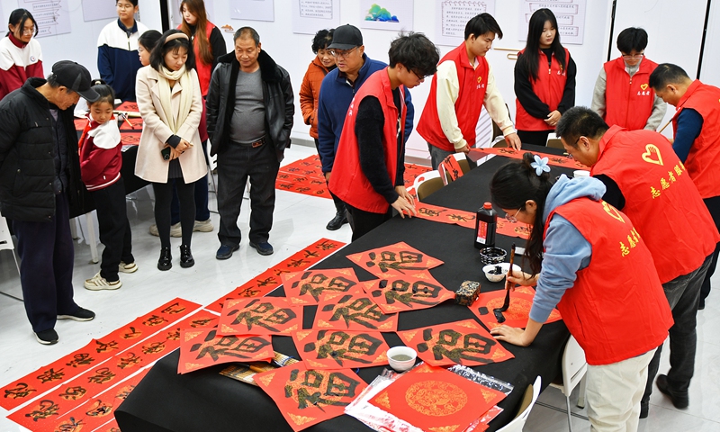 Calligraphy teachers from a school in Yantai, East China's Shandong Province, write couplets and the character fu, which means good fortune, for community residents on December 17, 2024. The couplets and characters will be used to decorate people's homes for the upcoming Chinese New Year. Photo: VCG