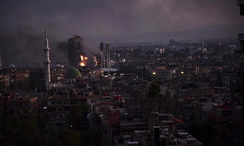 This photo taken on Dec. 8, 2024, shows thick smoke after an explosion in Damascus, Syria. Syrian militant alliance seized full control of Damascus on Sunday (Dec. 8), ending the rule of Bashar al-Assad. Russia's Foreign Ministry issued a statement saying al-Assad had decided to leave the presidential post and left the country, giving instructions to transfer power peacefully. (Photo by Monsef Memari/Xinhua)