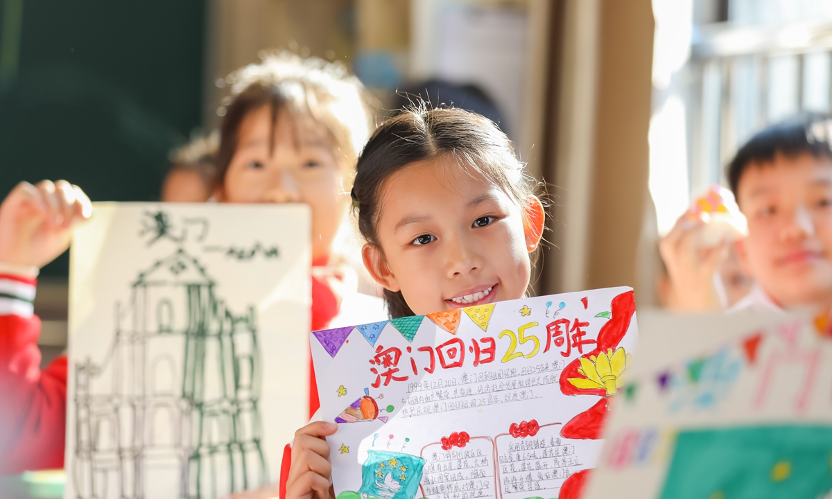 Students at Wushan Primary School in Fuzhou, capital of East China's Fujian Province, showcase their handmade posters celebrating the 25th anniversary of Macao's return to the motherland on December 18, 2024. Photo: IC