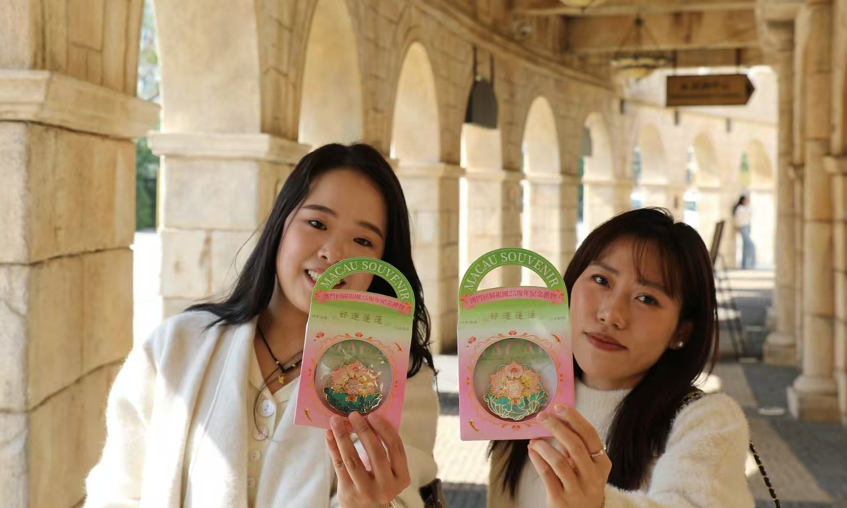 Two young women hold up cultural products representing Macao on December 17, 2024. Photo: Lin Xiaoyi/GT 