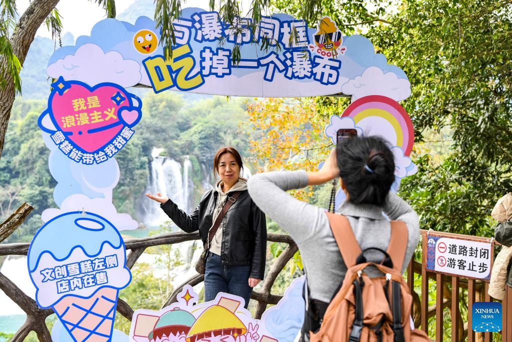 A tourist poses for photos in the China-Vietnam Detian-Ban Gioc Waterfall cross-border tourism cooperation zone on Dec. 15, 2024.(Xinhua/Cao Yiming)