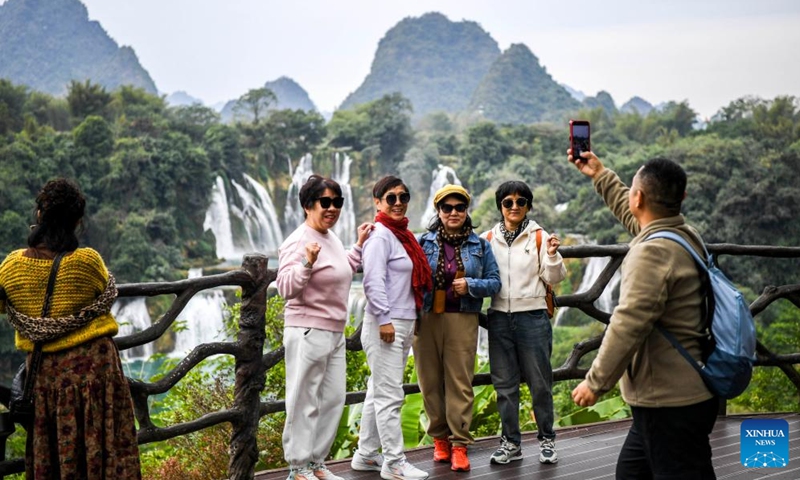 Tourists pose for photos in the China-Vietnam Detian-Ban Gioc Waterfall cross-border tourism cooperation zone on Dec. 15, 2024. (Xinhua/Cao Yiming)