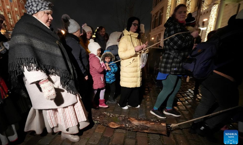 People pull a block in Riga, Latvia, Dec. 19, 2024.The traditional block-pulling event took place here on Thursday, which symbolically removes the old and gives way to the new year. (Photo by Edijs Palens/Xinhua)