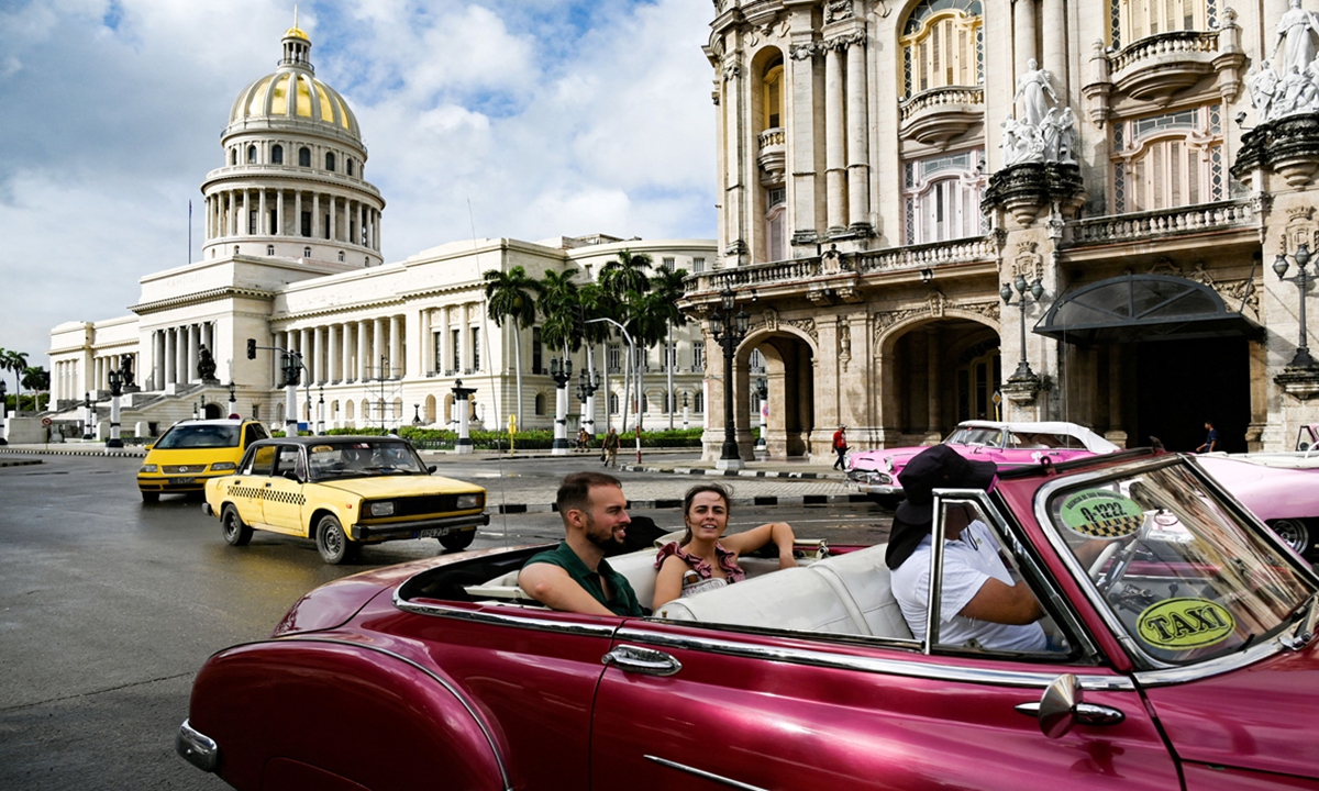 Tourists ride in a classic car in Havana, Cuba, as the local power company reports that electricity has been restored to half of the city on October 21, 2024. Power outages had affected the entire country previously. Photo: VCG