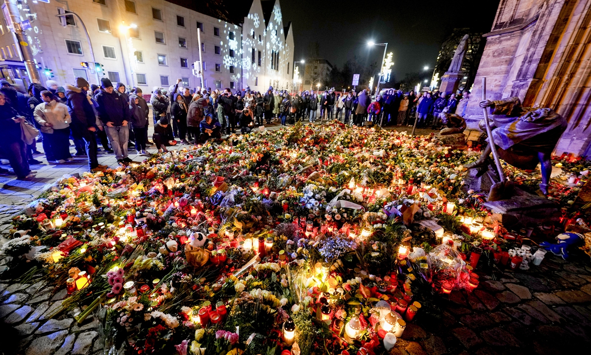 People lay flowers and candles in front of the Johannis church close to the Christmas market, December 21, 2024, where a car drove into a crowd on Friday evening, in Magdeburg, Germany. Photo: VCG