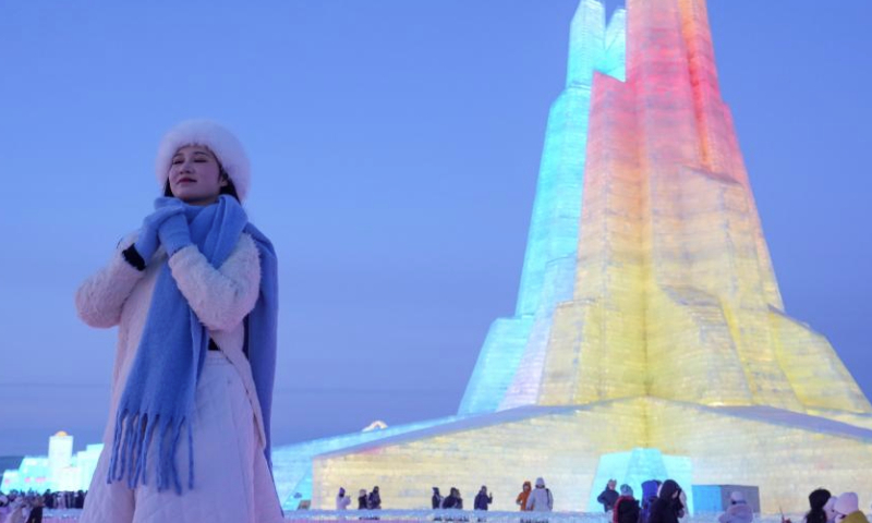 A visitor poses for photos at the Harbin Ice-Snow World in Harbin, northeast China's Heilongjiang Province, Jan. 5, 2025. The 41st Harbin International Ice and Snow Festival kicked off here on Sunday with the theme Dream of Winter, Love among Asia. (Xinhua/Wang Jianwei)