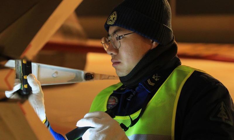 A maintenance man assigned to a regiment of the Chinese PLA Naval Aviation University conducts pre-flight inspections on a jet trainer during a flight training exercise in late November, 2024. (eng.chinamil.com.cn/Photo by Lan Pengfei)