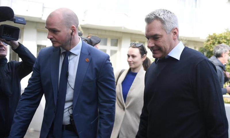 This file photo taken on Sept. 29, 2024 shows Austrian Chancellor Karl Nehammer (R) walking to a polling station in Vienna, Austria.  (Xinhua/He Canling)