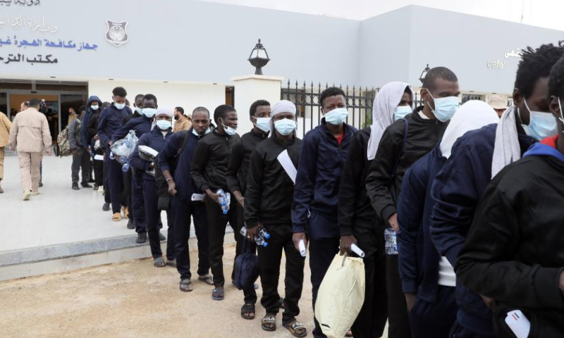 Migrants line up to get on a bus outside the Deportation Office of the Libyan Illegal Migration Control Department in Tripoli, Libya, on Dec. 25, 2024. (Photo by Hamza Turkia/Xinhua)