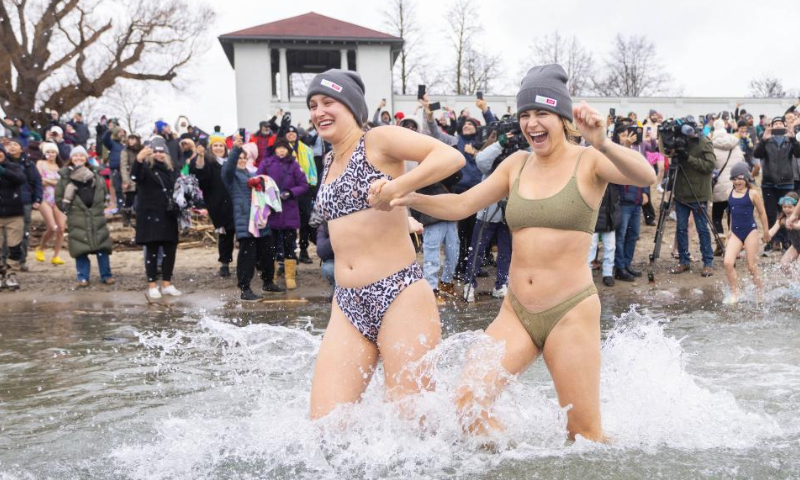 Participants rush into Lake Ontario during the Toronto Polar Bear Dip event in Toronto, Canada, on Jan. 1, 2025. Hundreds of people braved the chilly waters here on Wednesday to celebrate the first day of 2025 and raise funds for charity. (Photo by Zou Zheng/Xinhua)