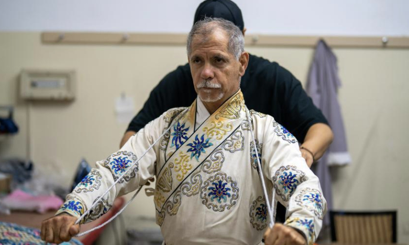 Ghaffar Pourazar puts on Peking Opera costumes in Beijing, capital of China, Sept. 30, 2024. (Xinhua/Ren Ke)