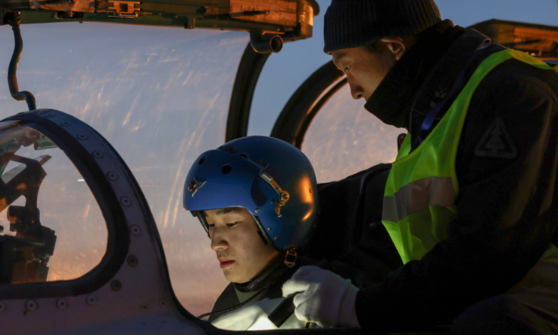 A cadet pilot assigned to a regiment of the Chinese PLA Naval Aviation University makes preparations for the flight with the help of a maintenance man before a flight training exercise in late November, 2024. (eng.chinamil.com.cn/Photo by Lan Pengfei)