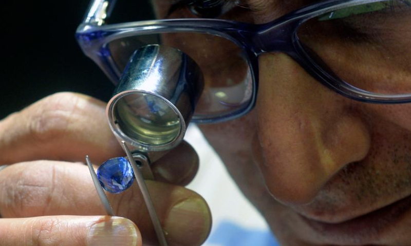 A man checks a gemstone on display during FACETS Sri Lanka 2025, an international gem and jewellery exhibition, in Colombo, Sri Lanka, Jan. 4, 2025. The exhibition opened here Saturday. (Photo by Gayan Sameera/Xinhua)