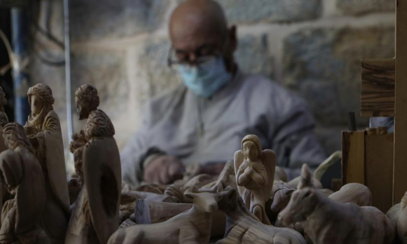 A craftsman works at a workshop in the West Bank city of Bethlehem, Dec. 23, 2024. Revered as the site of Jesus Christ's birth, Bethlehem sees a muted Christmas season this year as tourists stay away amid the Israeli ongoing attacks on the Gaza Strip. (Photo by Mamoun Wazwaz/Xinhua)