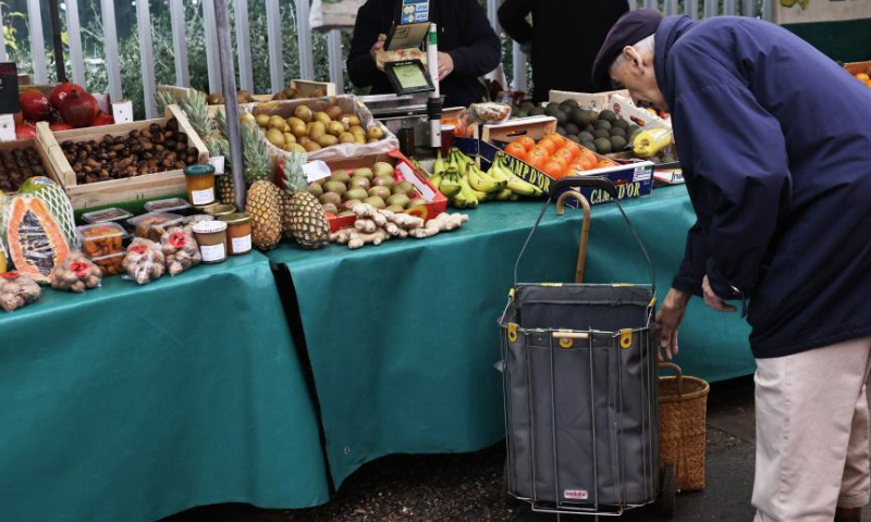 A resident purchases fruit at a market ahead of Christmas eve in Paris, France, Dec. 24, 2024. (Xinhua/Gao Jing)