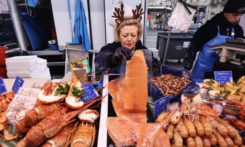 Vendors work at Maree d'Auteuil, a seafood stall, ahead of Christmas eve in Paris, France, Dec. 24, 2024. (Xinhua/Gao Jing)