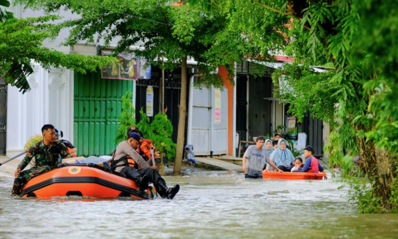 People ride rubber boats in flood water after heavy rain hit Makassar, South Sulawesi Province, Indonesia, on Dec. 24, 2024. Floods and landslides have been hitting several regions in the Southeast Asian archipelago in the past week. (Photo by Niaz Sharief/Xinhua)