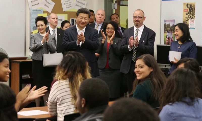 Chinese President Xi Jinping (back, 4th L) and his wife Peng Liyuan (back, 2nd L) greet teachers and students during their visit to Lincoln High School in Tacoma of Washington State, the United States, Sept. 23, 2015. (Xinhua/Liu Weibing)