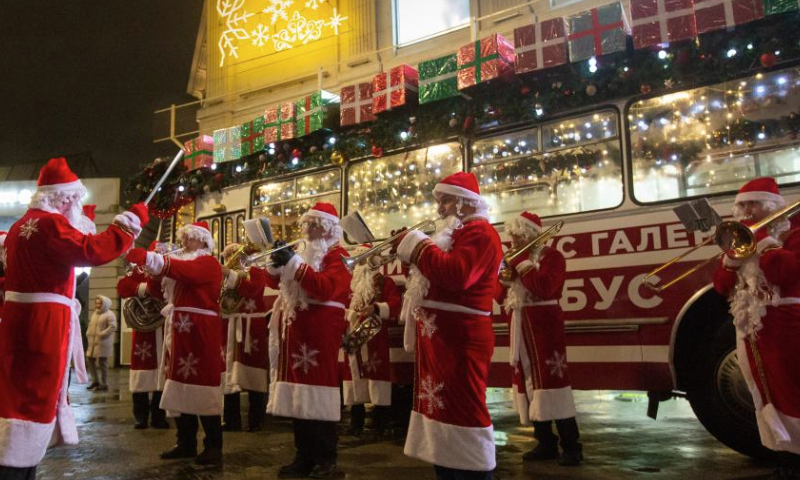 Musicians in Father Frost costumes play music for citizens in St. Petersburg, Russia, Dec. 25, 2024. Musicians in holiday costumes took a holiday bus around the Russian city to play music and distribute gifts to citizens in celebration of the upcoming New Year. (Photo by Irina Motina/Xinhua)