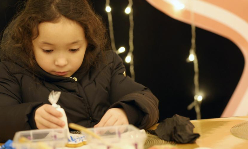 A girl does handwork during a New Year event in Bishkek, Kyrgyzstan, Dec. 25, 2024. (Photo by Roman Gainanov/Xinhua)