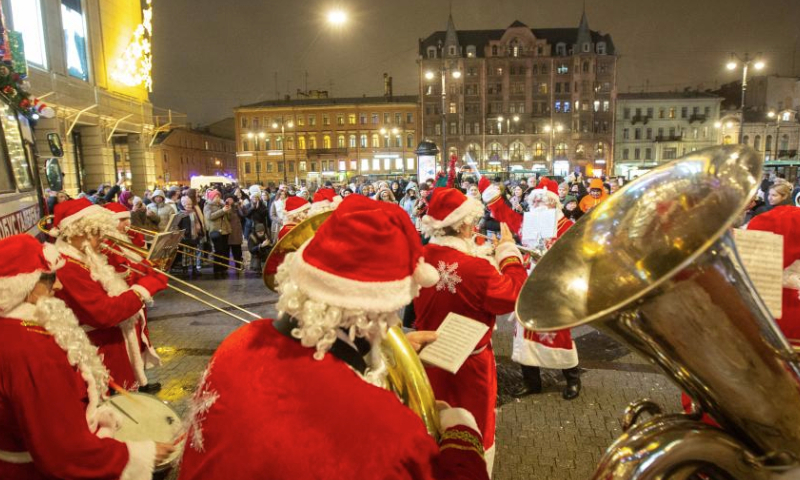 Musicians in Father Frost costumes play music for citizens in St. Petersburg, Russia, Dec. 25, 2024. Musicians in holiday costumes took a holiday bus around the Russian city to play music and distribute gifts to citizens in celebration of the upcoming New Year. (Photo by Irina Motina/Xinhua)