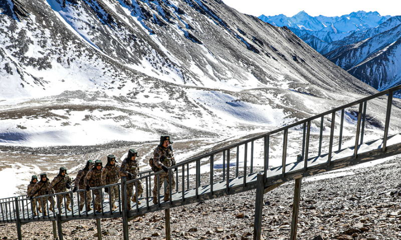 Border defense officers and soldiers assigned to the Aksu Military Sub-command of the Chinese PLA Xinjiang Military Command step up stairs during a routine patrol mission on December 11, 2024. (eng.chinamil.com.cn/Photo by Wang Junqiang)