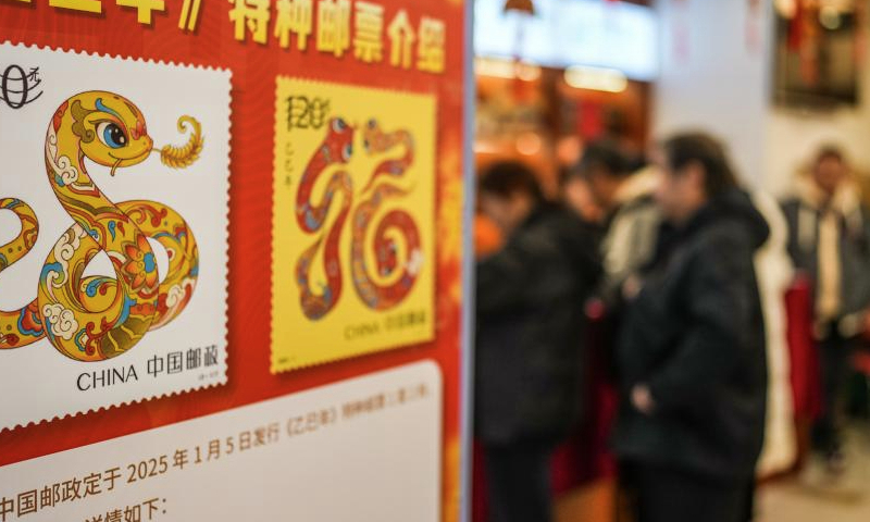 People wait to buy special stamps marking the Year of the Snake at a post office in Guiyang, southwest China's Guizhou Province, Jan. 5, 2025. China Post on Sunday unveiled a set of two special stamps to celebrate the upcoming Chinese zodiac Year of the Snake. (Xinhua/Tao Liang)