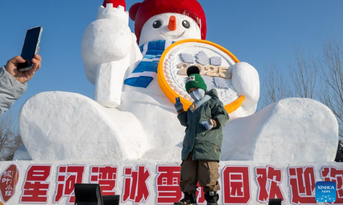 A boy poses for photos with a snowman at an ice and snow amusement park in Harbin, capital of northeast China's Heilongjiang Province, Jan. 4, 2025. Harbin, with many snow sculptures across the city, has emerged as one of China's top winter travel destinations, attracting tourists from around the globe. (Photo: Xinhua)