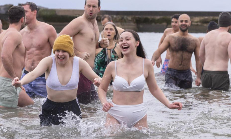 Participants wade in Lake Ontario during the Toronto Polar Bear Dip event in Toronto, Canada, on Jan. 1, 2025. Hundreds of people braved the chilly waters here on Wednesday to celebrate the first day of 2025 and raise funds for charity. (Photo by Zou Zheng/Xinhua)