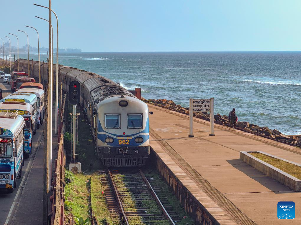 This photo taken with a mobile phone shows a train by the sea in Colombo, Sri Lanka, Dec. 26, 2024. The coastal railway line, located on the west coast of Sri Lanka and close to the Indian Ocean, is a major railway line in this island country. It is also a famous tourist attraction. (Photo: Xinhua)