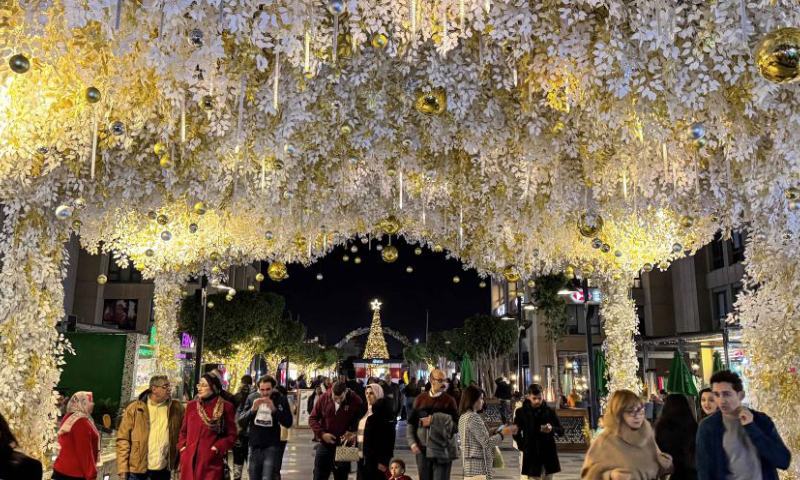 People are seen under a festive decoration at a shopping area in Cairo, Egypt, on Dec. 23, 2024. (Xinhua/Ahmed Gomaa)