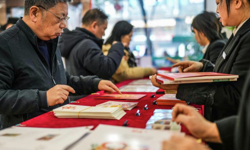 People buy special stamps marking the Year of the Snake at a post office in Guiyang, southwest China's Guizhou Province, Jan. 5, 2025. China Post on Sunday unveiled a set of two special stamps to celebrate the upcoming Chinese zodiac Year of the Snake. (Xinhua/Tao Liang)