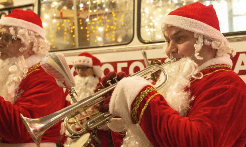 Musicians in Father Frost costumes play music for citizens in St. Petersburg, Russia, Dec. 25, 2024. Musicians in holiday costumes took a holiday bus around the Russian city to play music and distribute gifts to citizens in celebration of the upcoming New Year. (Photo by Irina Motina/Xinhua)