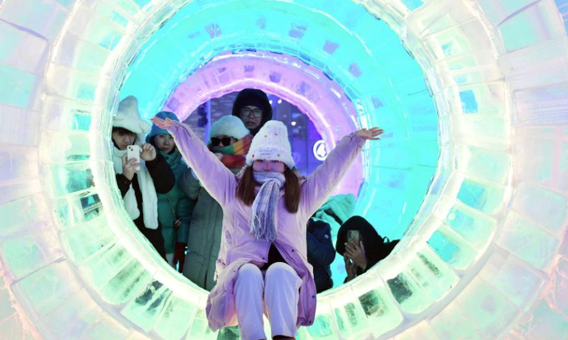 A visitor poses for photos at the Harbin Ice-Snow World in Harbin, northeast China's Heilongjiang Province, Jan. 5, 2025. The 41st Harbin International Ice and Snow Festival kicked off here on Sunday with the theme Dream of Winter, Love among Asia. (Photo by Liu Yang/Xinhua)