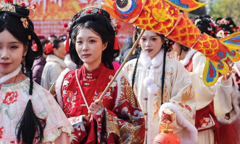 People in traditional Hanfu attire participate in a parade at a New Year fair in Shangcheng District of Hangzhou, east China's Zhejiang Province, Dec. 31, 2024. The fair opened here on Tuesday, with themed sections showcasing intangible cultural heritage, cultural and creative products, folk custom, and folk arts native to Hangzhou. Specialty food and deli are also made available there, adding a festive atmosphere to the city. (Xinhua/Xu Yu)