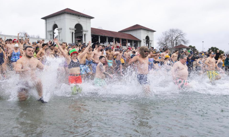 Participants rush into Lake Ontario during the Toronto Polar Bear Dip event in Toronto, Canada, on Jan. 1, 2025. Hundreds of people braved the chilly waters here on Wednesday to celebrate the first day of 2025 and raise funds for charity. (Photo by Zou Zheng/Xinhua)