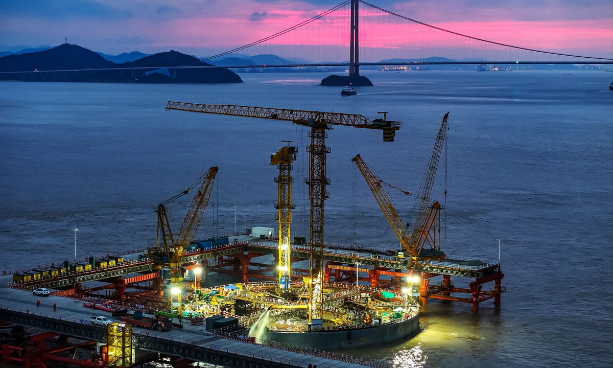 Workers carry out the ballast cleaning and bottom sealing operation based on the caisson set on the No. 4 main tower at the construction site of the No. 4 main pier of the Xihoumen Road-rail Bridge of Yongzhou Railway in Zhoushan, East China's Zhejiang Province, on December 23, 2024. Photo: VCG