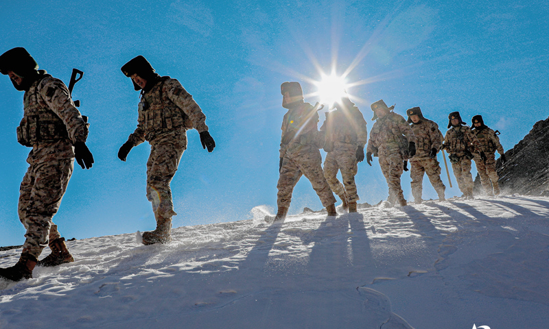 Border defense officers and soldiers assigned to the Aksu Military Sub-command of the Chinese PLA Xinjiang Military Command walk down a snow-covered slope during a routine patrol mission on December 11, 2024. (eng.chinamil.com.cn/Photo by Wang Junqiang)